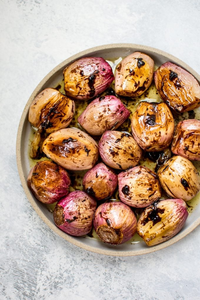 plate of whole roasted shallots with balsamic vinegar and butter