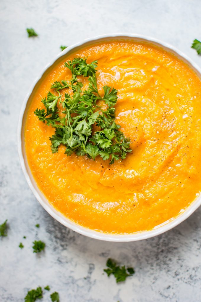 close-up of carrot celeriac soup in a bowl topped with parsley
