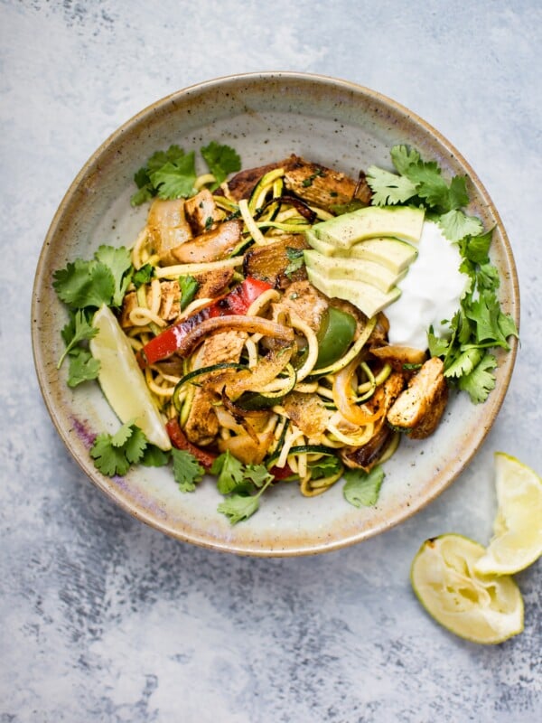 These chicken fajita zoodle bowls are a low-carb way to get your fajita fix! Topped with avocado, Greek yogurt, and fresh cilantro, they make a light and tasty meal. 