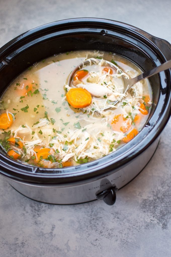 lemon chicken orzo soup inside a Crockpot with ladle