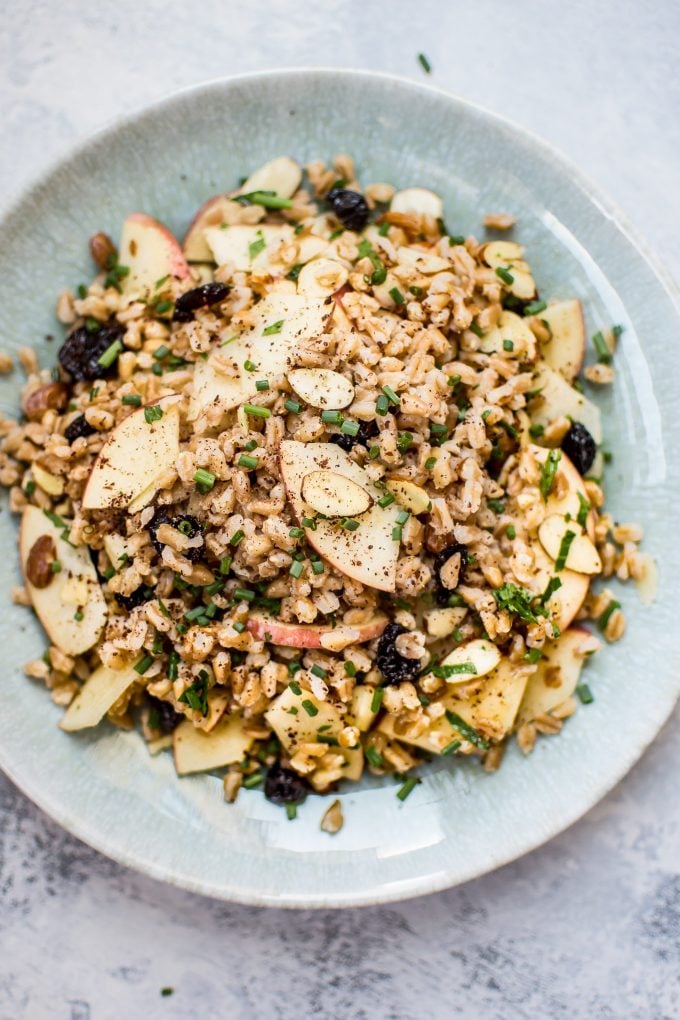 close-up of fall farro salad with cranberries and almonds on a teal plate