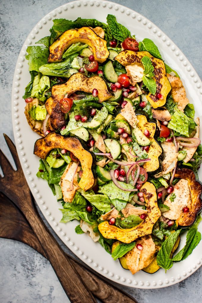 serving platter of fall fattoush salad with wooden salad utensils