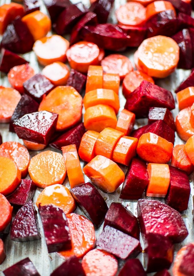 process shot of raw beets and carrots on a sheet pan