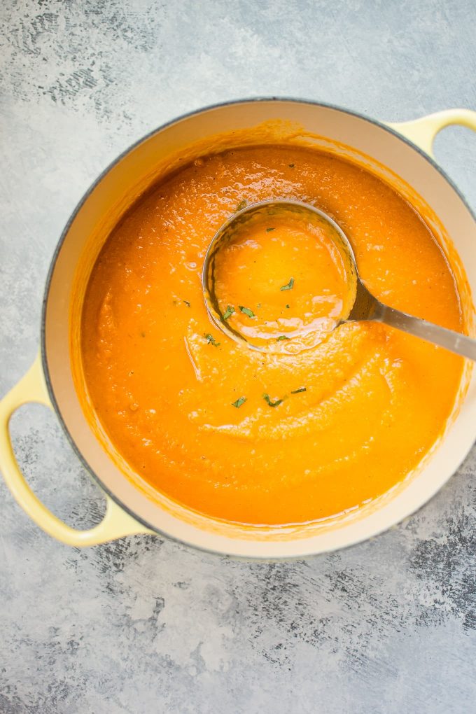 yellow pot with spicy sweet potato soup and ladle