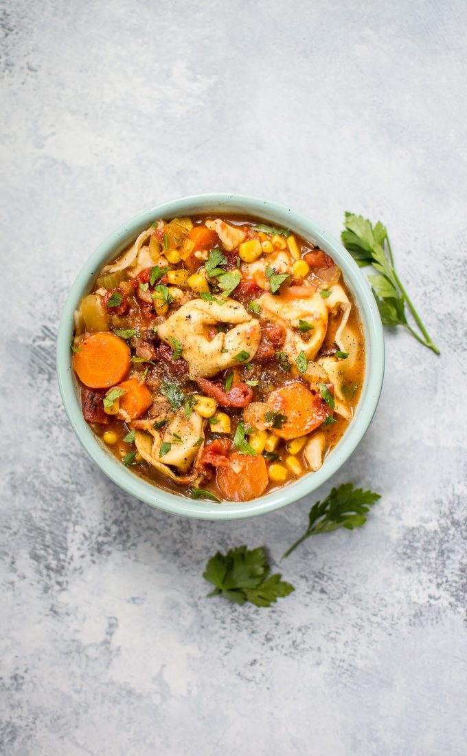 bowl with vegetarian tortellini soup and parsley sprigs