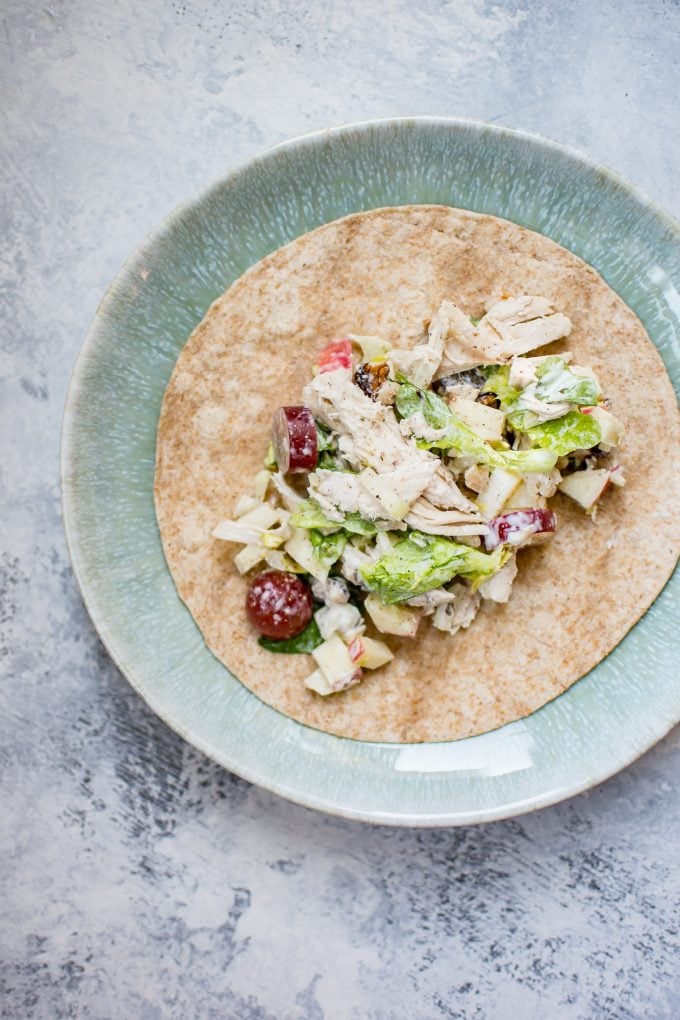 tortilla wrap with Waldorf chicken salad on a teal plate