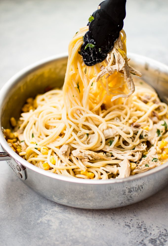 skillet with creamy leftover turkey pasta and serving tongs