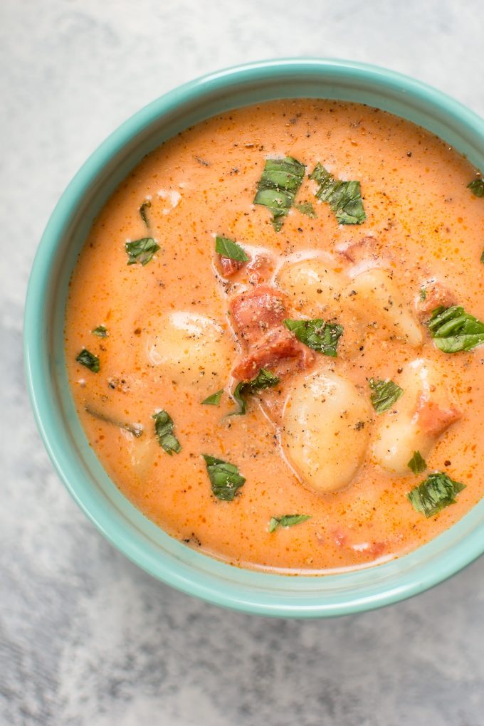 close-up of creamy tomato gnocchi soup in a teal bowl