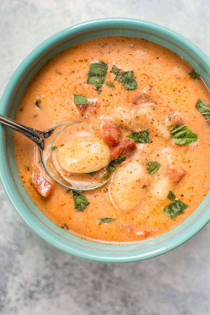 close-up of creamy tomato gnocchi soup with a spoon