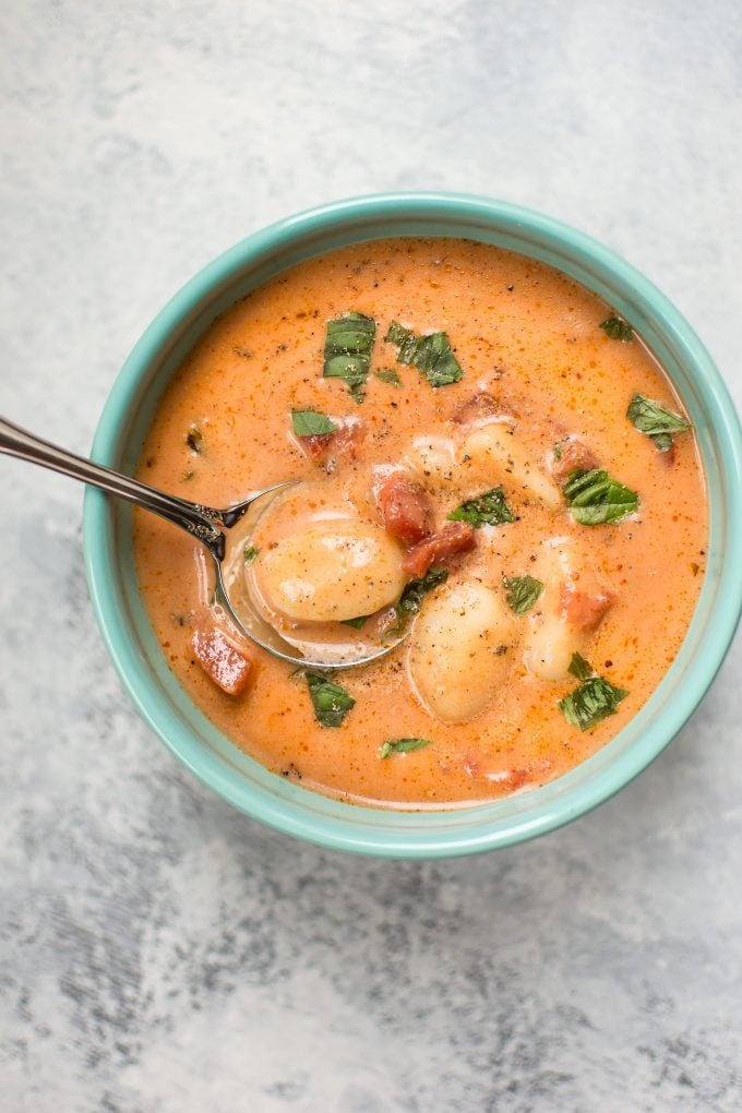 bowl of creamy tomato gnocchi soup with a spoon