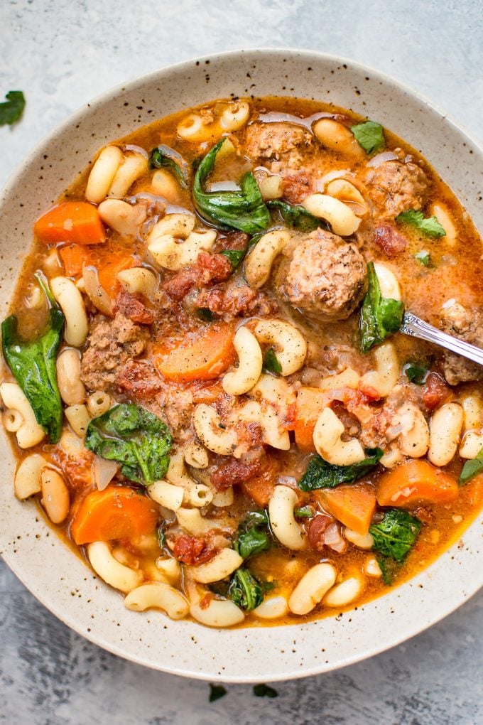 close-up of slow cooker Italian sausage soup in a bowl with a spoon