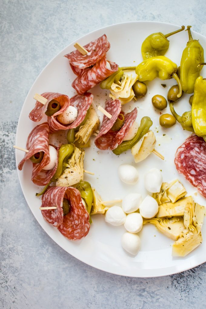 plate of antipasto skewers and ingredients like bocconcini and pepperoncini
