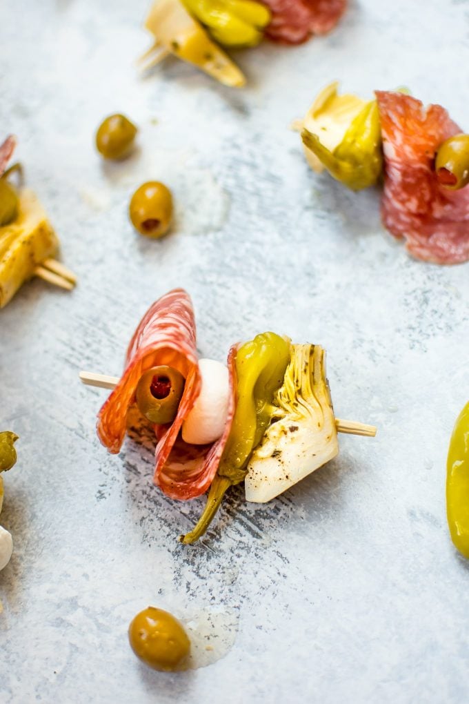 an easy antipasto skewer with salami beside olives