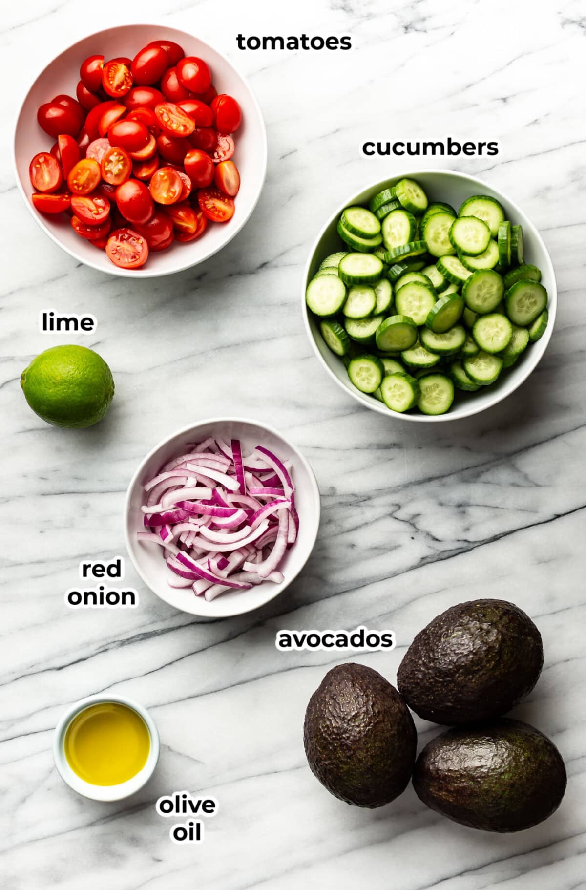 ingredients for cucumber tomato avocado salad in prep bowls