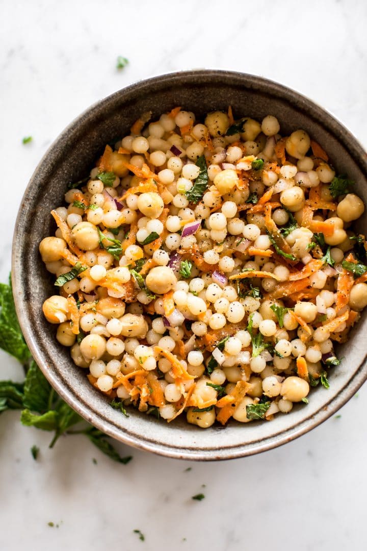 This healthy vegan pearl couscous salad has delicious fresh herbs, chickpeas, and carrots. It's the perfect light lunch or meal prep recipe.