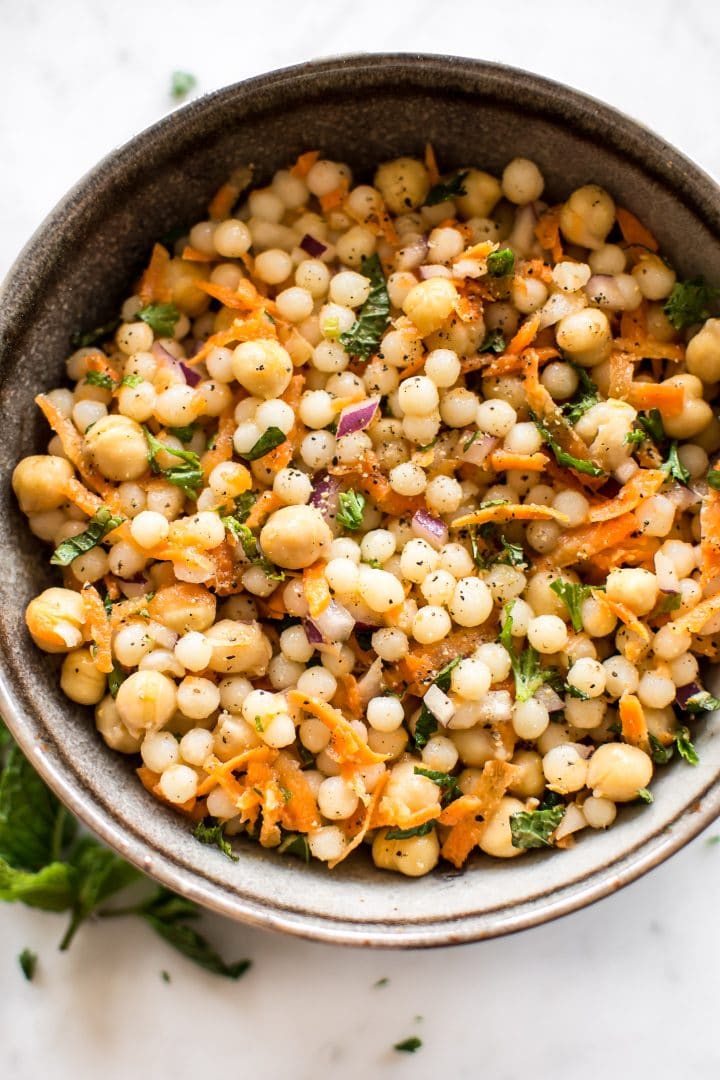 This healthy vegan pearl couscous salad has delicious fresh herbs, chickpeas, and carrots. It's the perfect light lunch or meal prep recipe.