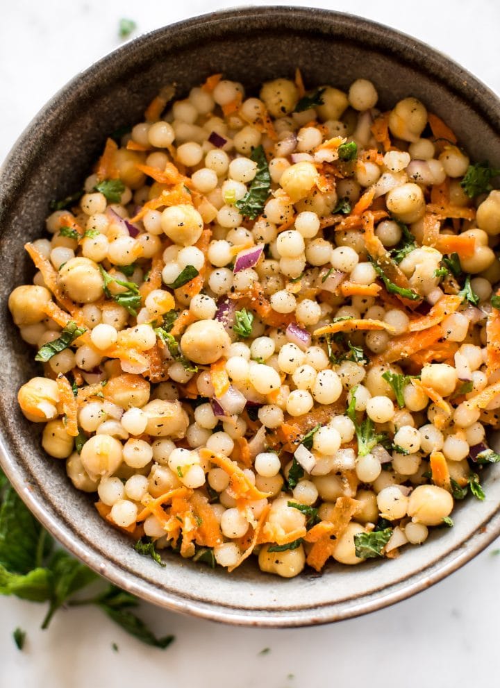 This healthy vegan pearl couscous salad has delicious fresh herbs, chickpeas, and carrots. It's the perfect light lunch or meal prep recipe.