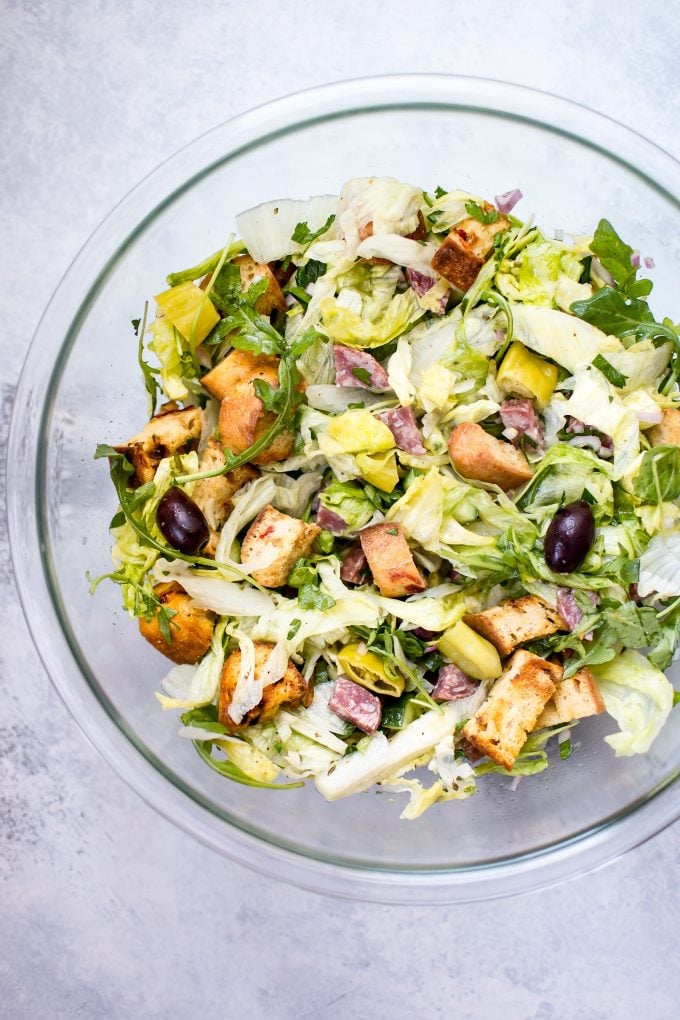 glass bowl with Italian chopped salad with salami and peppers