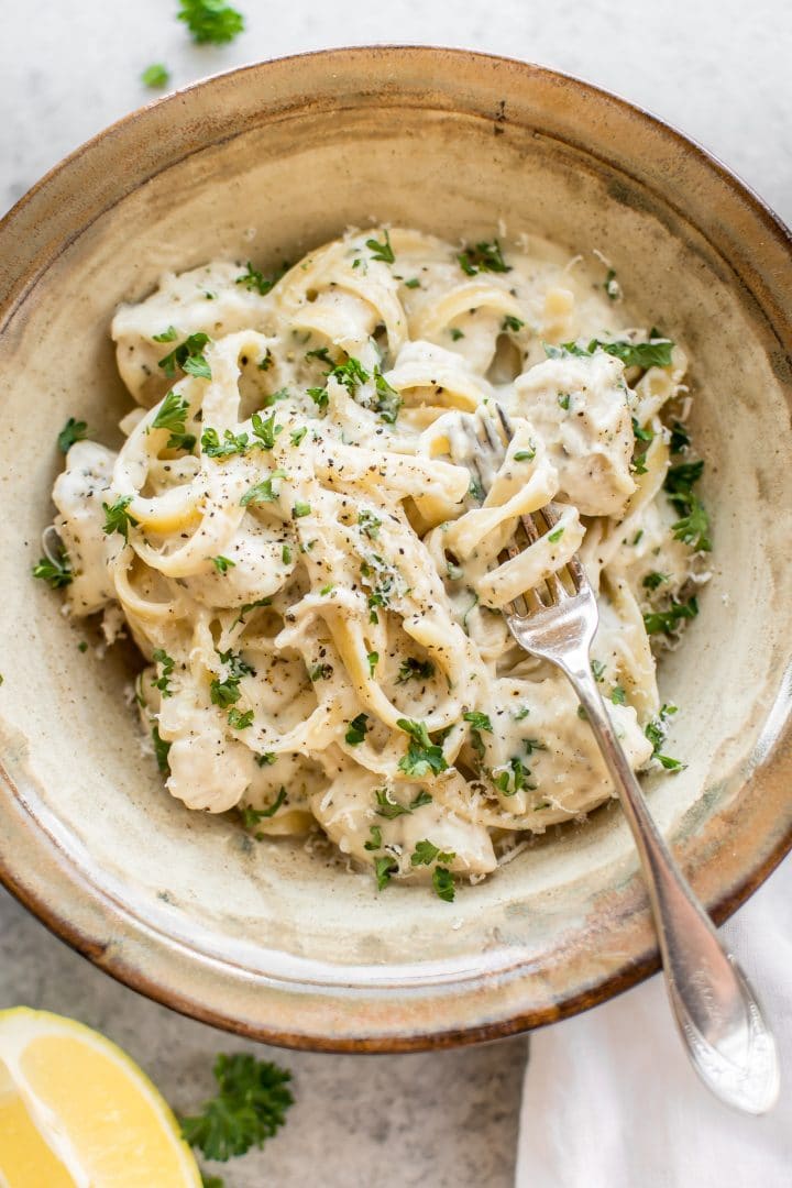 a bowl of creamy chicken alfredo with lemon, garlic, and parmesan