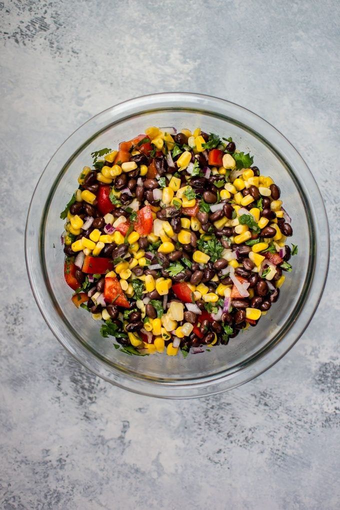 glass mixing bowl with ingredients for southwest spicy chicken taco bowls