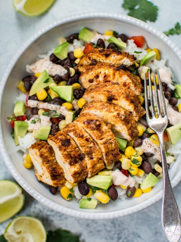 These spicy chicken taco bowls are simple, healthy, and delicious. Spicy southwest seasoning, fresh toppings, and a tangy creamy drizzle make these bowls irresistible! 