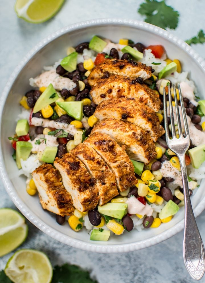 These spicy chicken taco bowls are simple, healthy, and delicious. Spicy southwest seasoning, fresh toppings, and a tangy creamy drizzle make these bowls irresistible! 