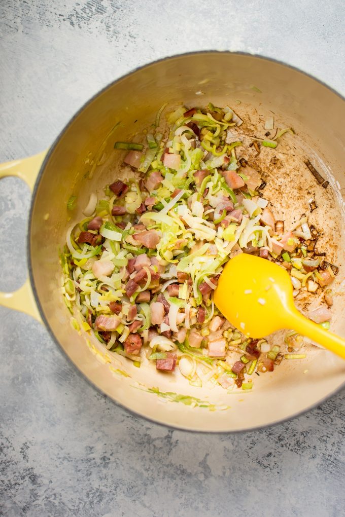 a pot with ingredients for white bean potato soup with pancetta