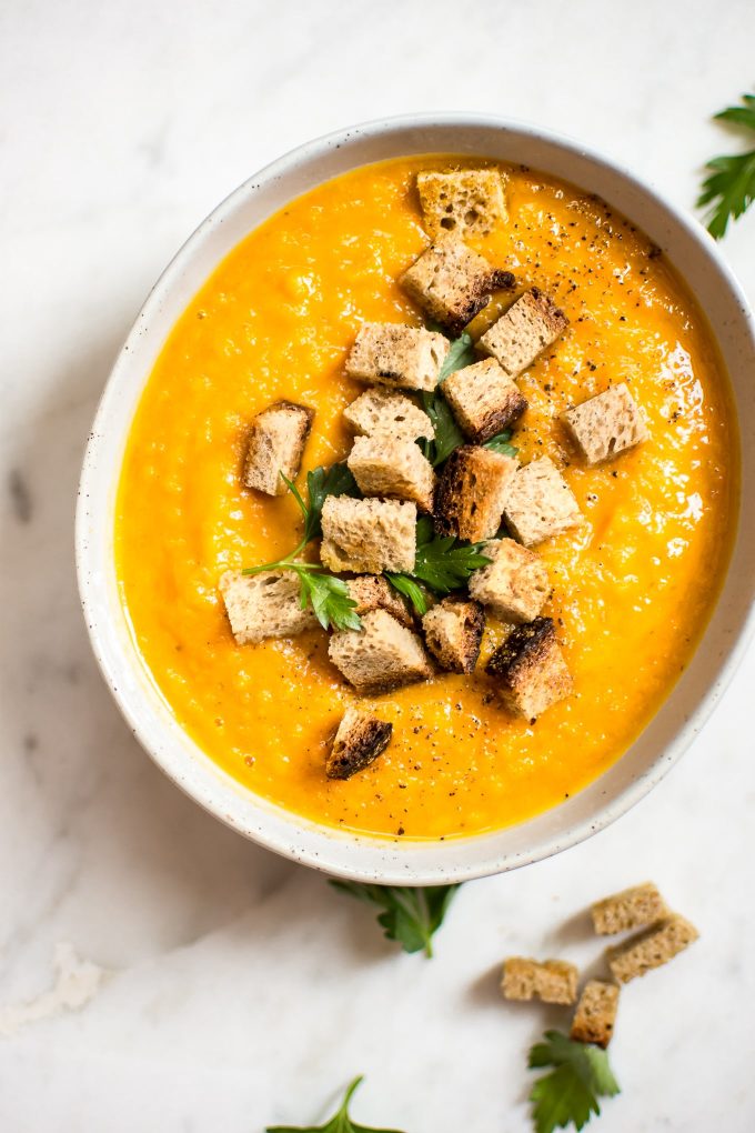 close-up of healthy butternut squash carrot soup in a bowl topped with croutons