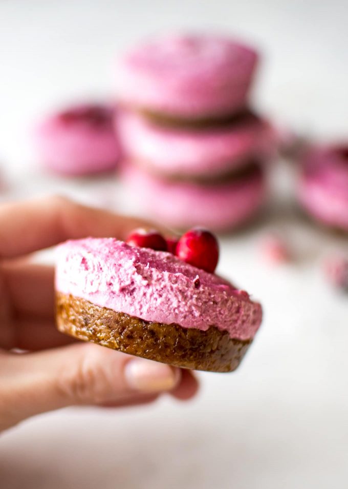 female hand holding a cranberry vegan cheesecake