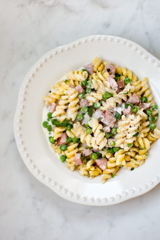 white bowl with one pot ham and pea pasta