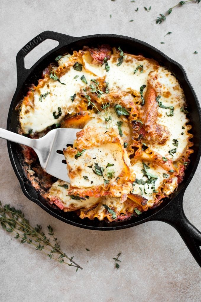 healthy vegetarian caprese skillet lasagna with serving spatula