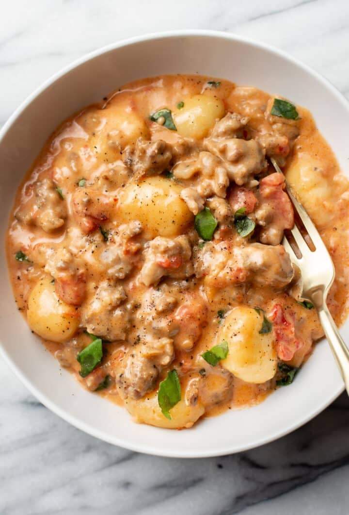 a bowl of creamy gnocchi with a fork