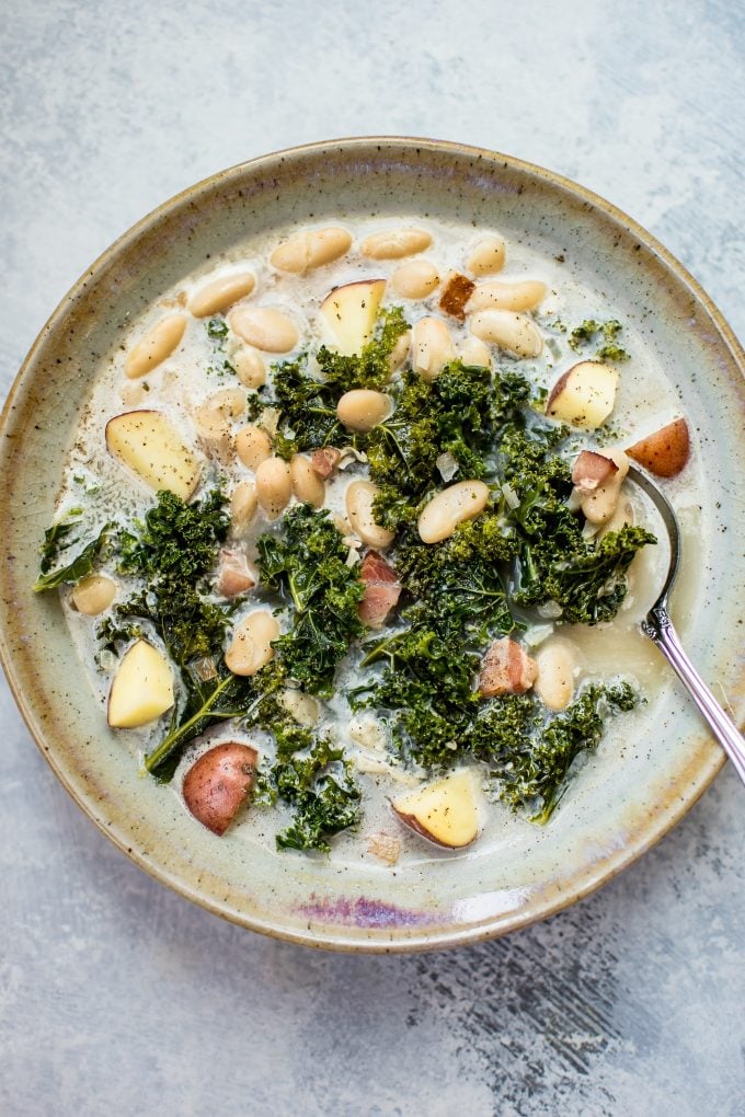 bowl of kale white bean soup with a spoon