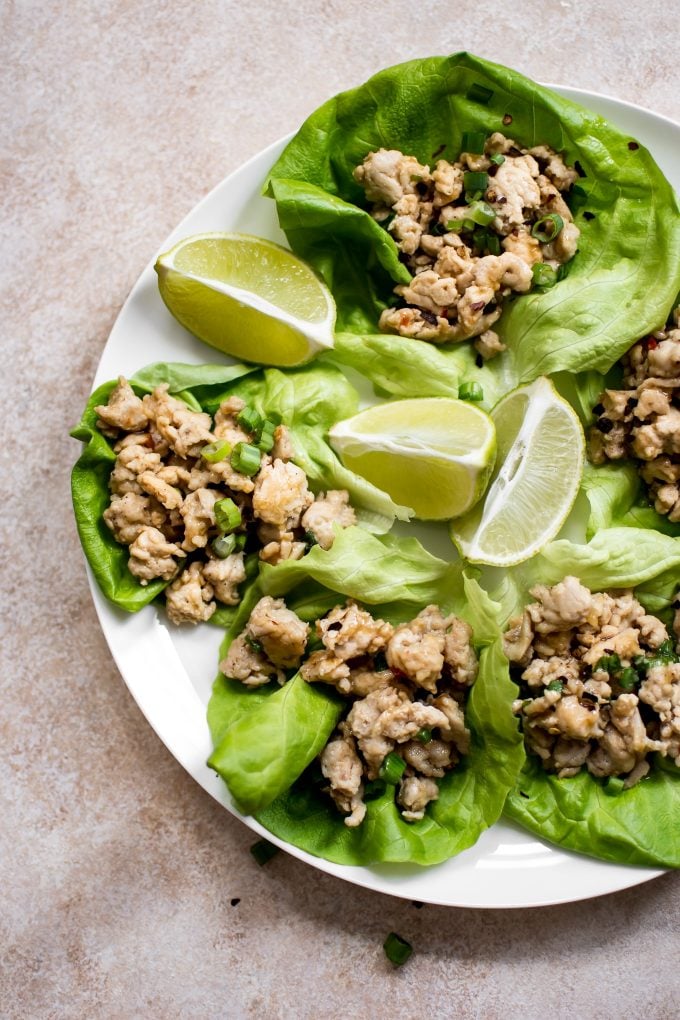 plate of sweet chili chicken lettuce wraps with lime wedges