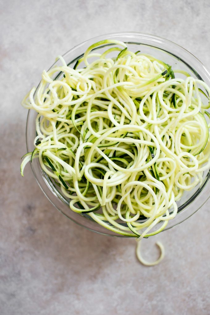 glass bowl with raw zucchini noodles