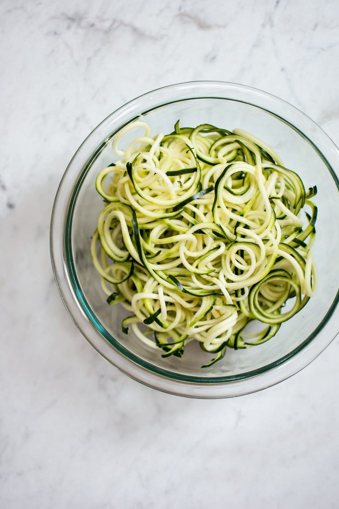 glass bowl with raw zucchini noodles