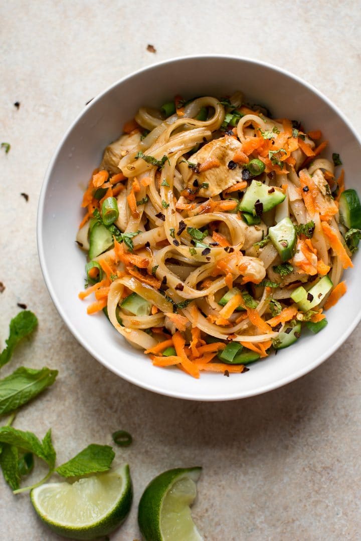 bowl of chicken stir fry with rice noodles and fresh vegetables