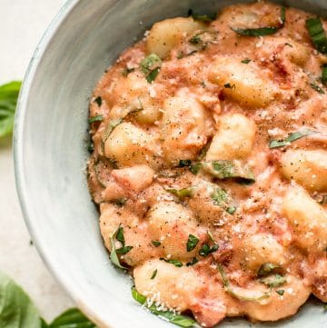 Gnocchi in a vodka cream sauce with tomatoes and basil. This gnocchi alla vodka recipe is ready in about 20 minutes! A delicious weeknight dinner.