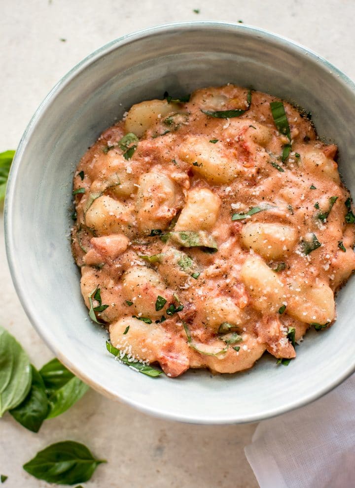 Gnocchi in a vodka cream sauce with tomatoes and basil. This gnocchi alla vodka recipe is ready in about 20 minutes! A delicious weeknight dinner.