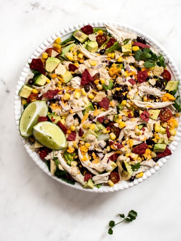 This healthy chicken taco salad recipe is fresh, filled with healthy goodies, and topped off with the most delicious chipotle ranch dressing.