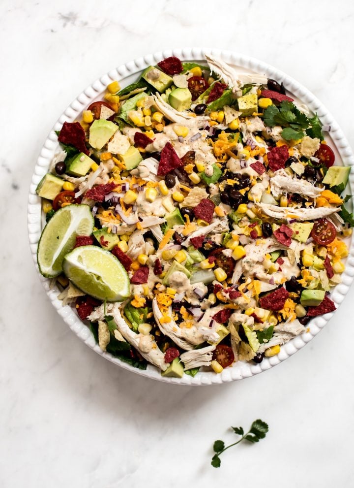 This healthy chicken taco salad recipe is fresh, filled with healthy goodies, and topped off with the most delicious chipotle ranch dressing.