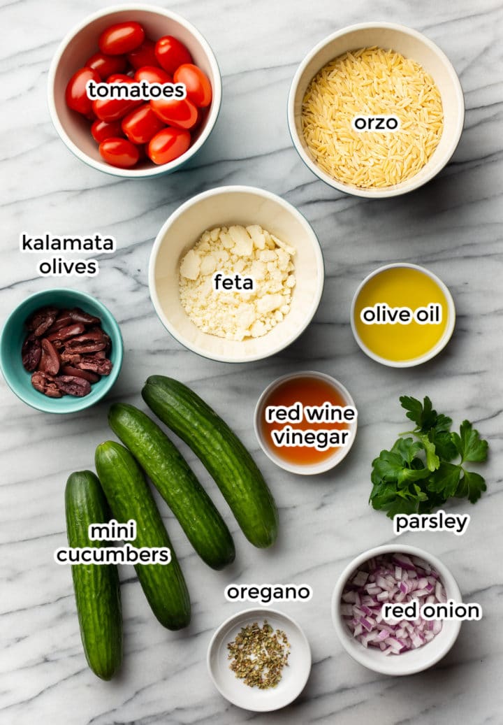 all the ingredients needed for mediterranean orzo salad in bowls on a counter