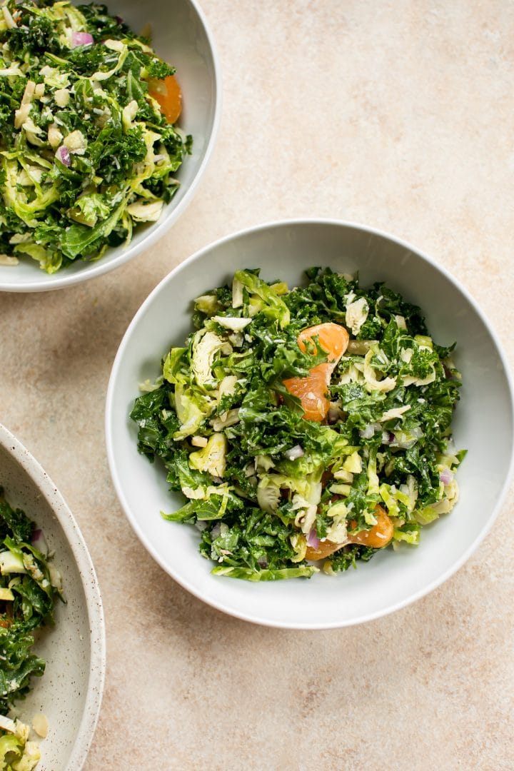 white bowls of shredded kale and Brussels sprouts salad