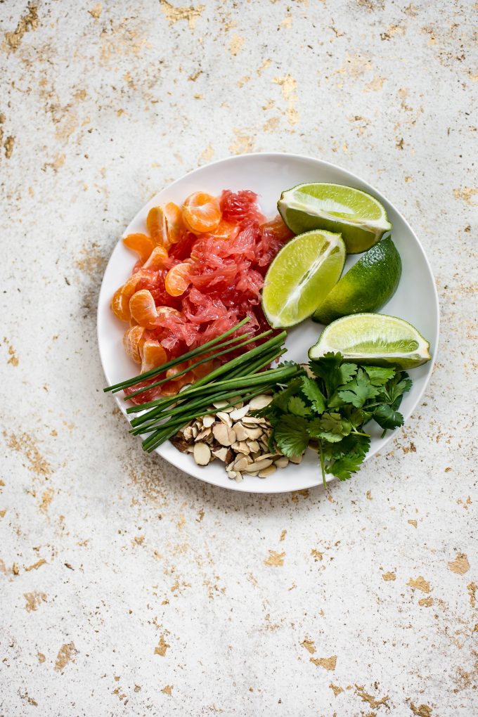 ingredients for shrimp citrus salad on a white plate