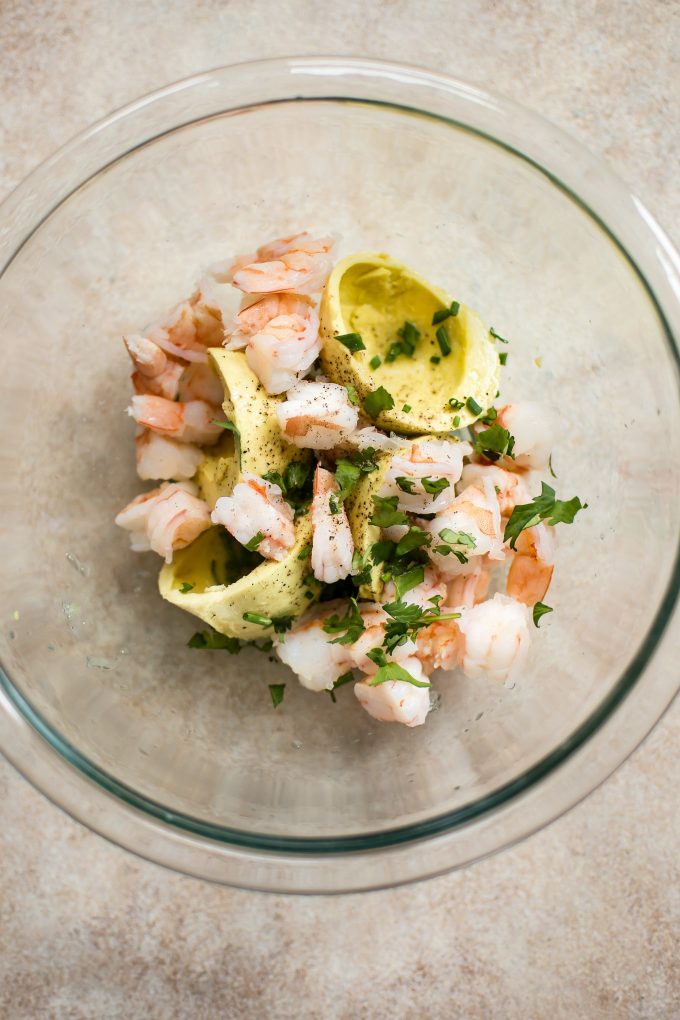 glass mixing bowl with ingredients for shrimp stuffed avocado halves