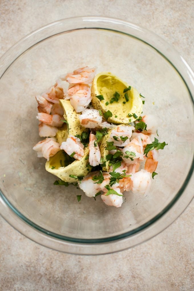 glass mixing bowl with ingredients for shrimp stuffed avocado halves