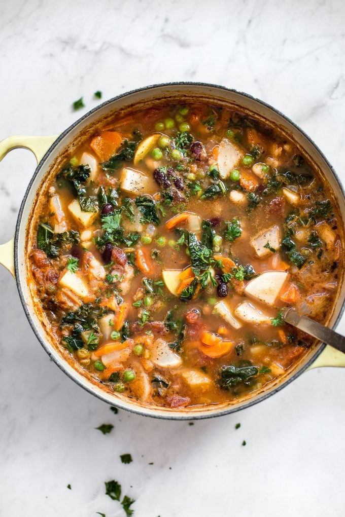 pot of vegetable and bean soup with a ladle