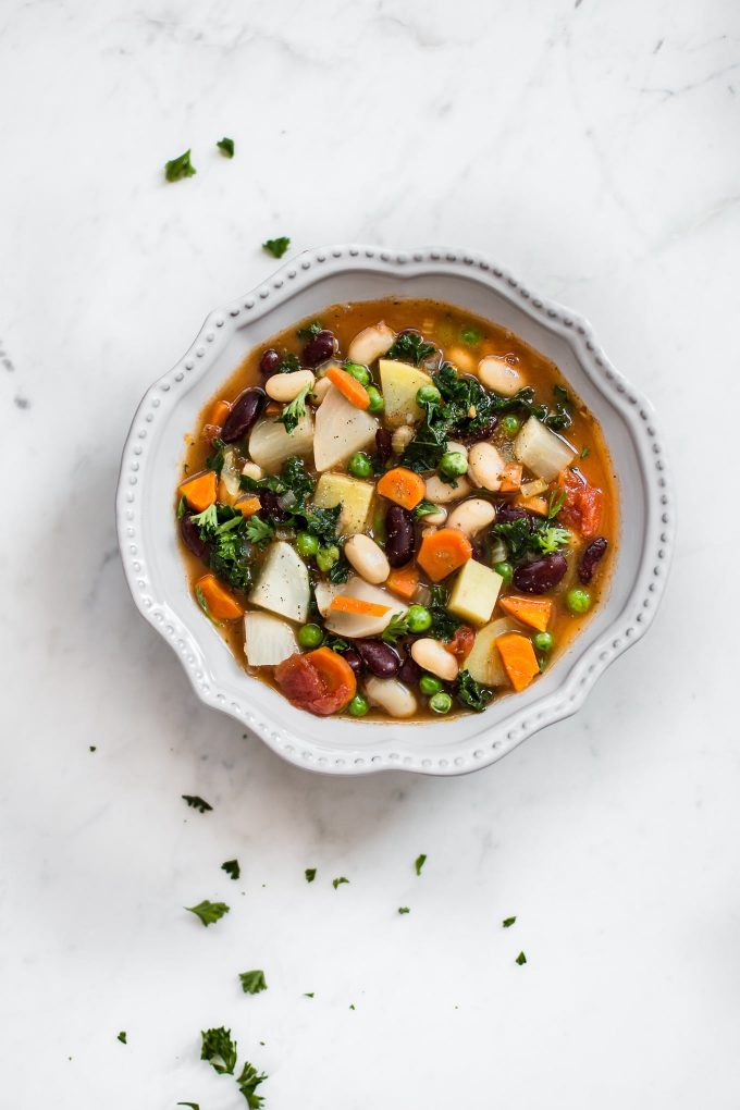 bowl of healthy vegetable and bean soup on a marble surface