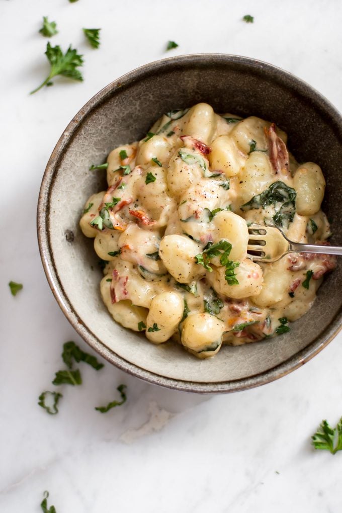 close-up of sun-dried tomato and basil gnocchi in a bowl with a fork