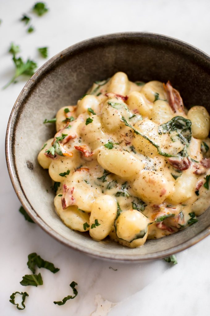 close-up of creamy sun-dried tomato and basil gnocchi in a bowl